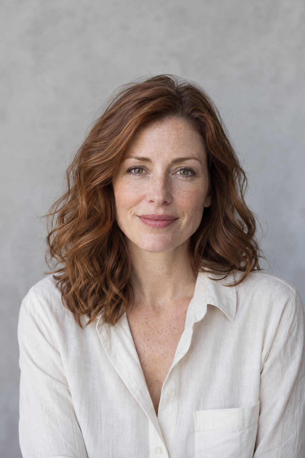 Mara Ellison editorial portrait, auburn hair and an ivory shirt